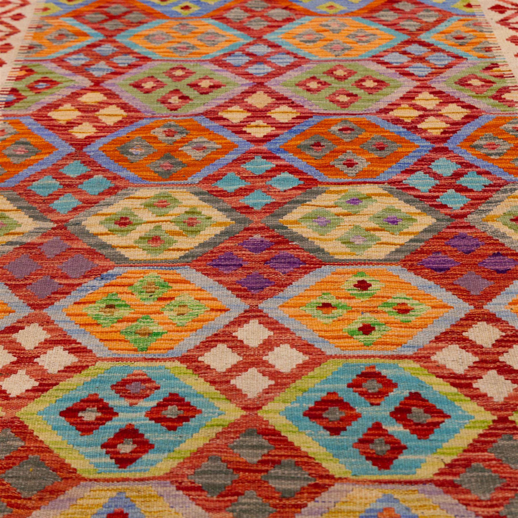 Turkish Anatolian flatweave kilim runner, ivory field decorated with rows of large polychrome lozenge medallions enclosing stylized geometric motifs with angular stepped borders, fringe ends 