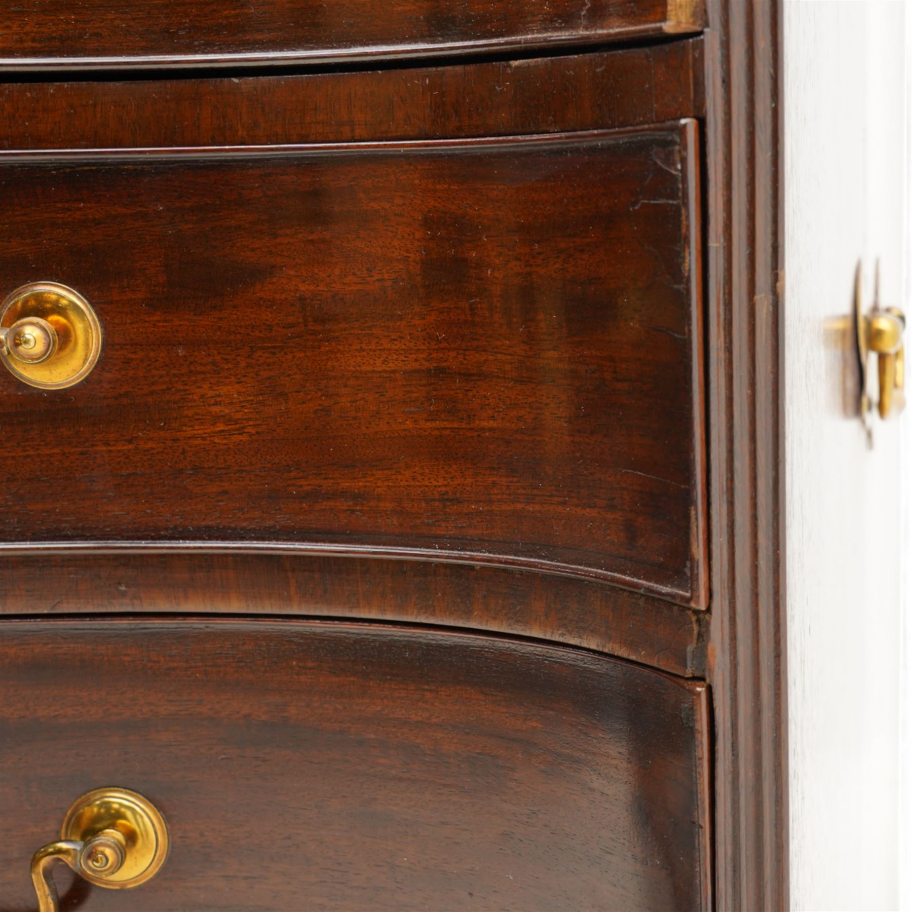 George III mahogany serpentine chest, moulded top over four cock-beaded drawers, the top drawer fitted with baize lined slide opening to reveal divisions,  enclosed by canted and fluted upright corners, the drawer fronts fitted with brass swan neck handles and circular plates with oval escutcheons, lower moulded edge over bracket feet, on lignum vitae castors
