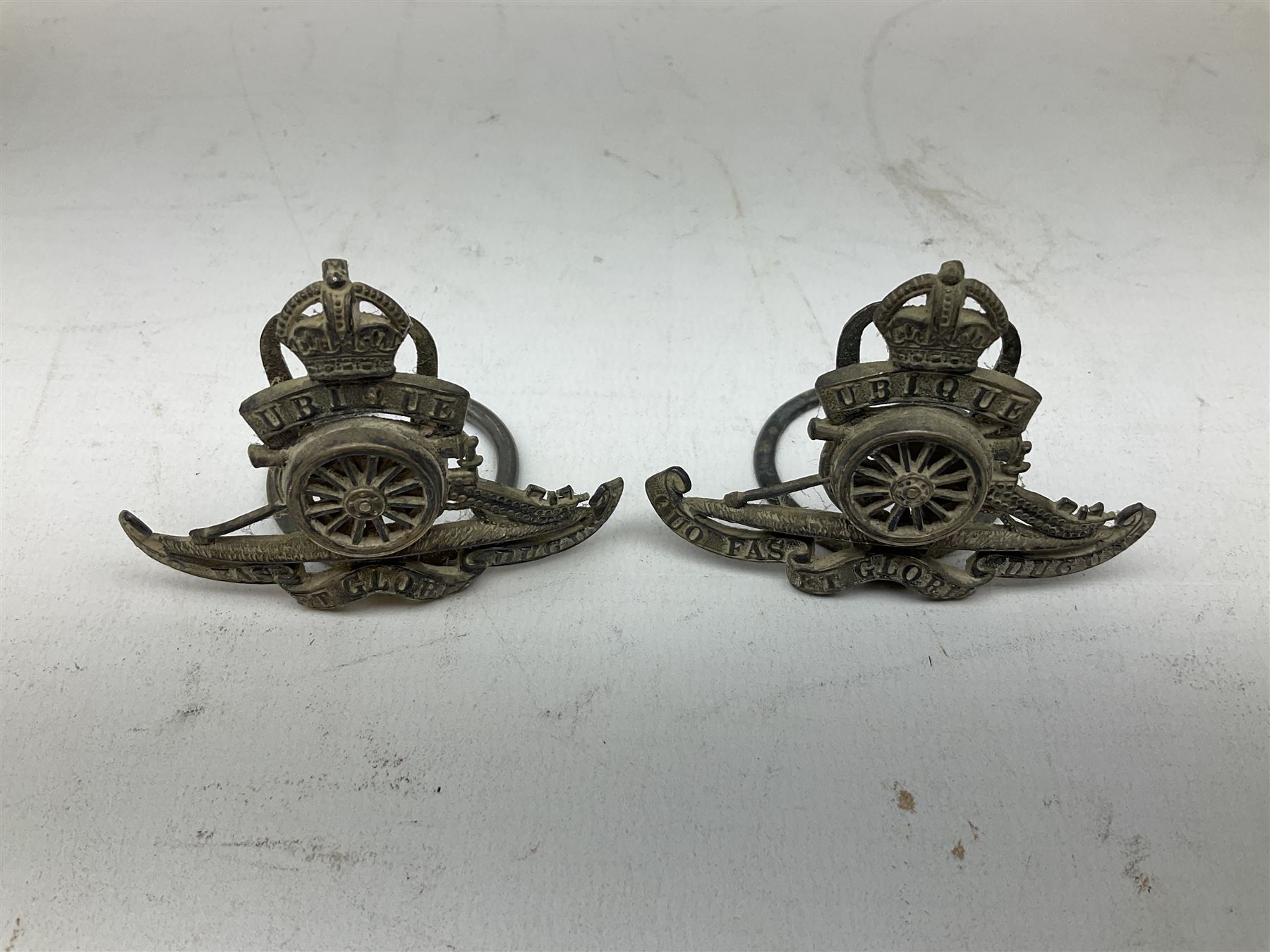 Trench Art - three WW2 brass shell case ashtrays, one mounted with Royal Artillery cap badge and button and one mounted with RA button; together with a pair of place name holders each formed from a Royal Artillery cap badge (5)