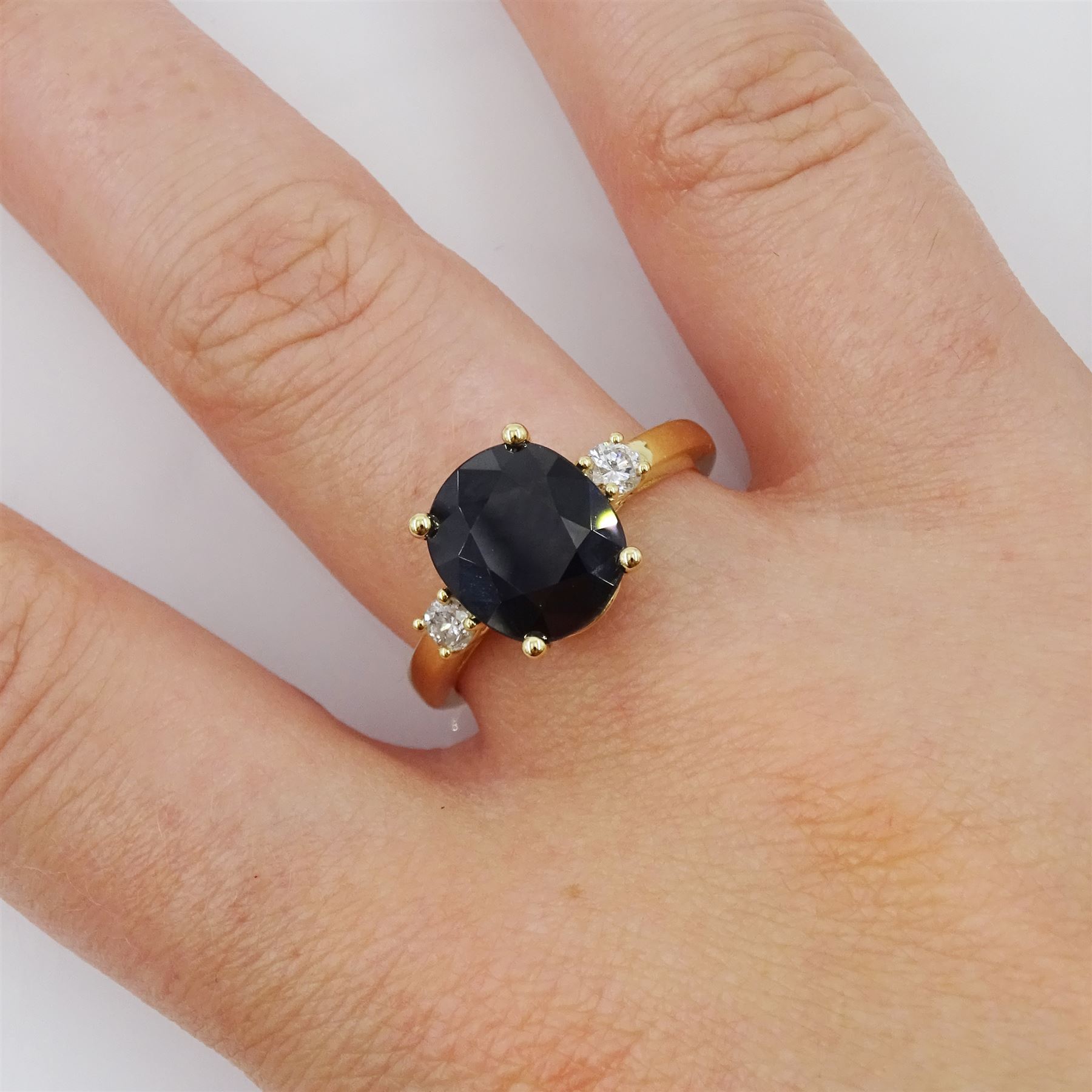 18ct gold sapphire and diamond three stone ring, single oval cut sapphire of approx 3.45 carat, with a round brilliant cut diamond set either side, hallmarked