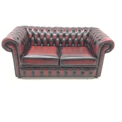 Two seat Chesterfield sofa upholstered in deep buttoned red leather, W165cm