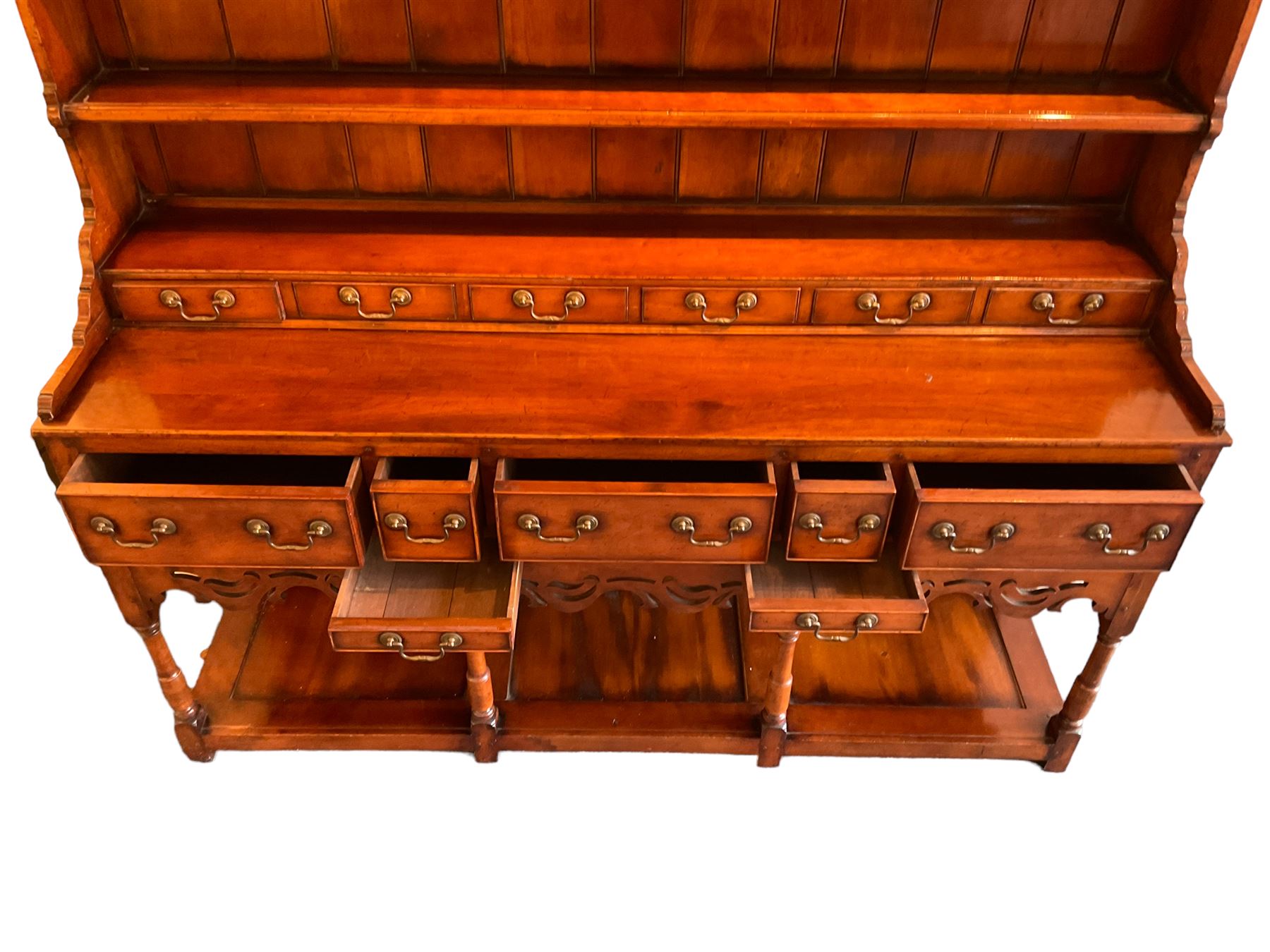 George III design cherry wood dresser, the projecting cornice over shaped frieze with pierced shell decoration, fitted with three shelves over six spice drawers, the base fitted with three long and two short drawers with cock-beaded facias, shaped and pierced apron over turned supports and panelled pot board base 