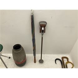 Two smooth polished ram horn handled Shepherd's crooks and a further similar example, together with various shooting sticks, walking sticks and canes, housed in a volcanic lava glaze West German style vase