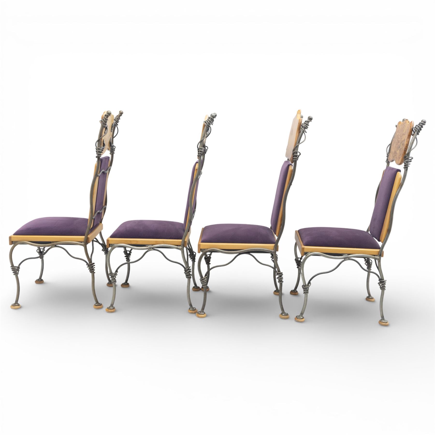 Paul Hodgkiss Designs of Glasgow - contemporary shaped elm dining table with wrought iron base; with set ten (8+2) matching high-back dining chairs, table of organic form above an elaborate wrought iron supports, with central elm stretcher, the chairs with en suite with matching wrought iron work burred elm headrest, purple velour upholstery with drop in seat     

Table: W 102cm, L 243cm, H 74cm
Chairs: W 56cm, D 52cm, H 130cm