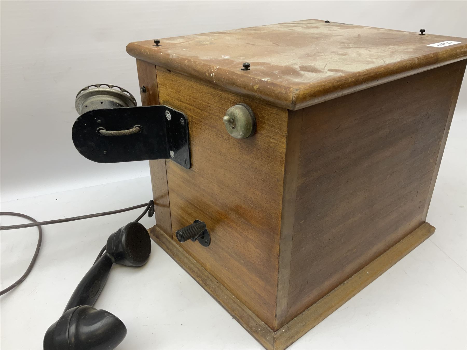 Early-mid 20th century internal telephone system, comprising exchange box with attached TMC rotary telephone and dictograph with Bakelite handset and support upon stained wood case, and 1960s black Bakelite telephone model 312L with G.P.O sticker beneath, largest H30.5cm W36.5cm D30cm