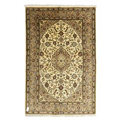 Central Persian Kashan hand-knotted rug, ivory ground, with a central shaped floral medall...