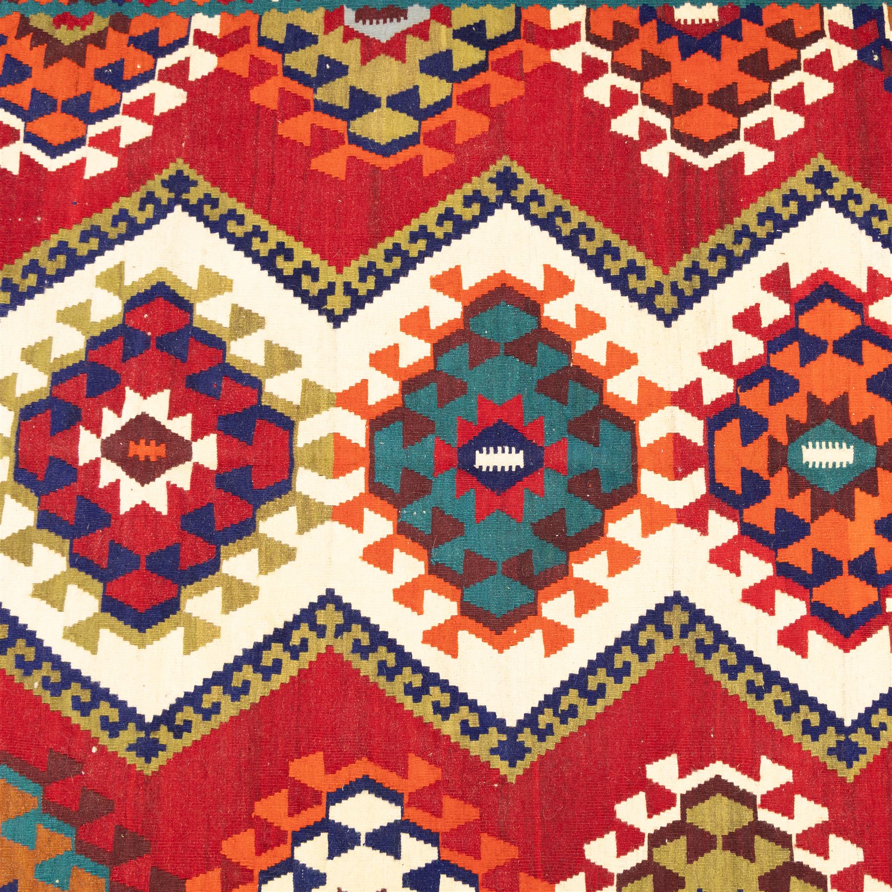 South west Persian Qashqai flatweave kilim, central field with a linked column of hooked diamond medallions in polychrome tones with an ivory lattice on a magenta ground framed by multiple geometric borders 