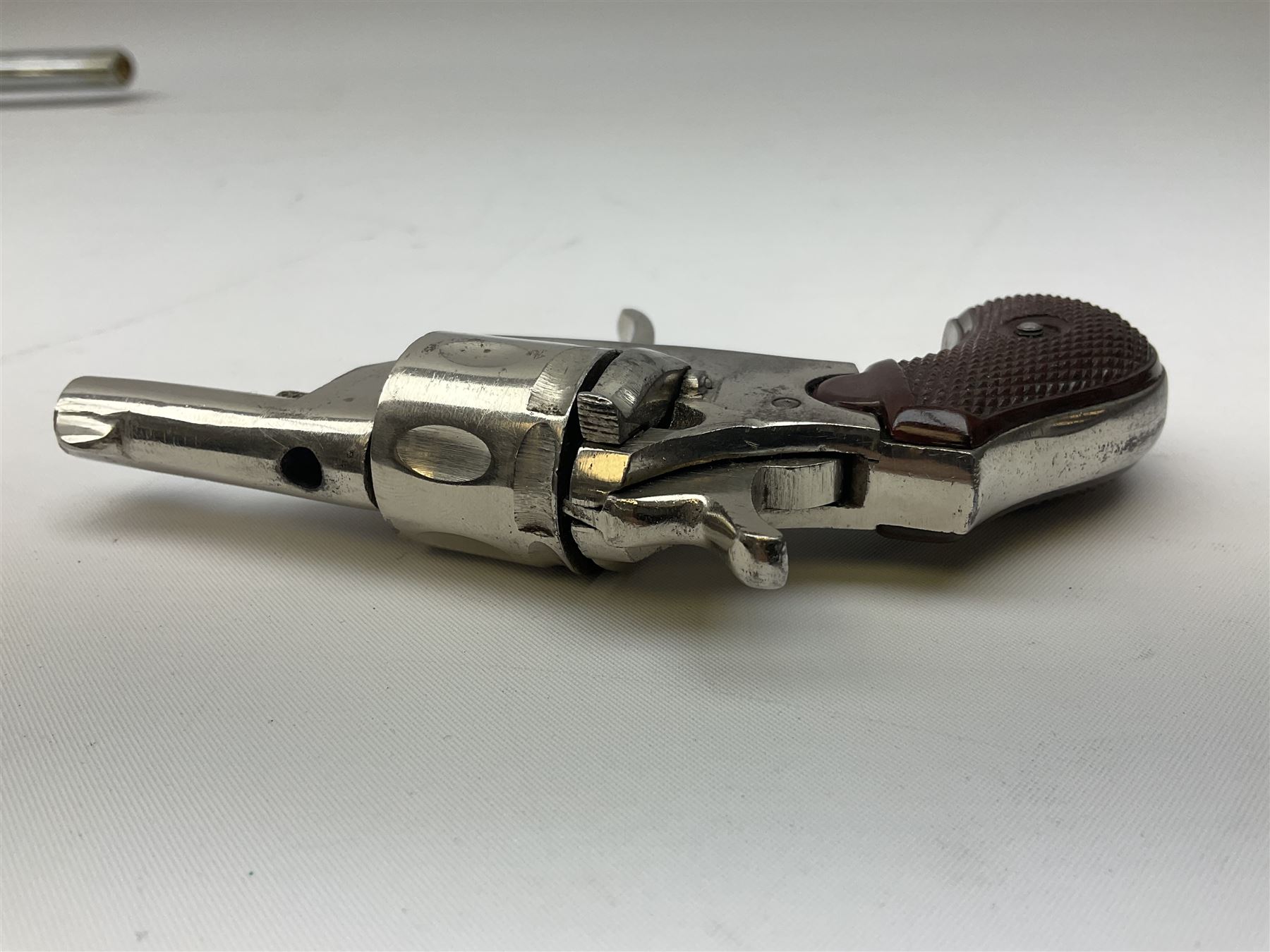 Early 20th century Flobert 5mm blank firing revolver with six-shot chamber, top venting, nickel plated with folding trigger No.118 L12.5cm overall; replica non-firing 'British Bulldog' revolver; and Windproof gas lighter inscribed 'Revolver-99 Spring and Autumn' in holster marked 'Star-Line'