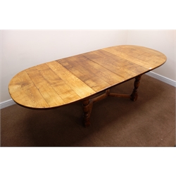 17th century style oak extending dining table with two leaves, curved ends, turned supports joined by an 'X' floor stretcher (W271cm, H75cm, D121cm) retailed by Geoffrey Benson  