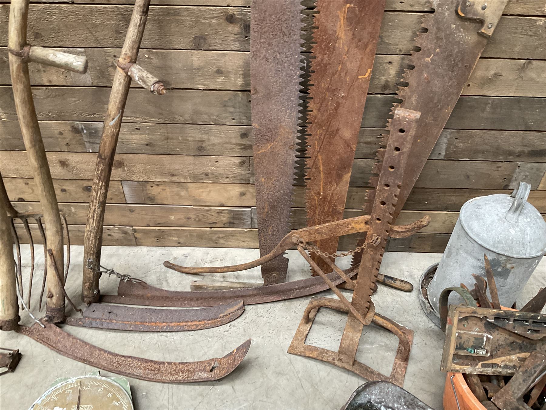 Large quantity of vintage hand tools including scales, scythes, saws etc