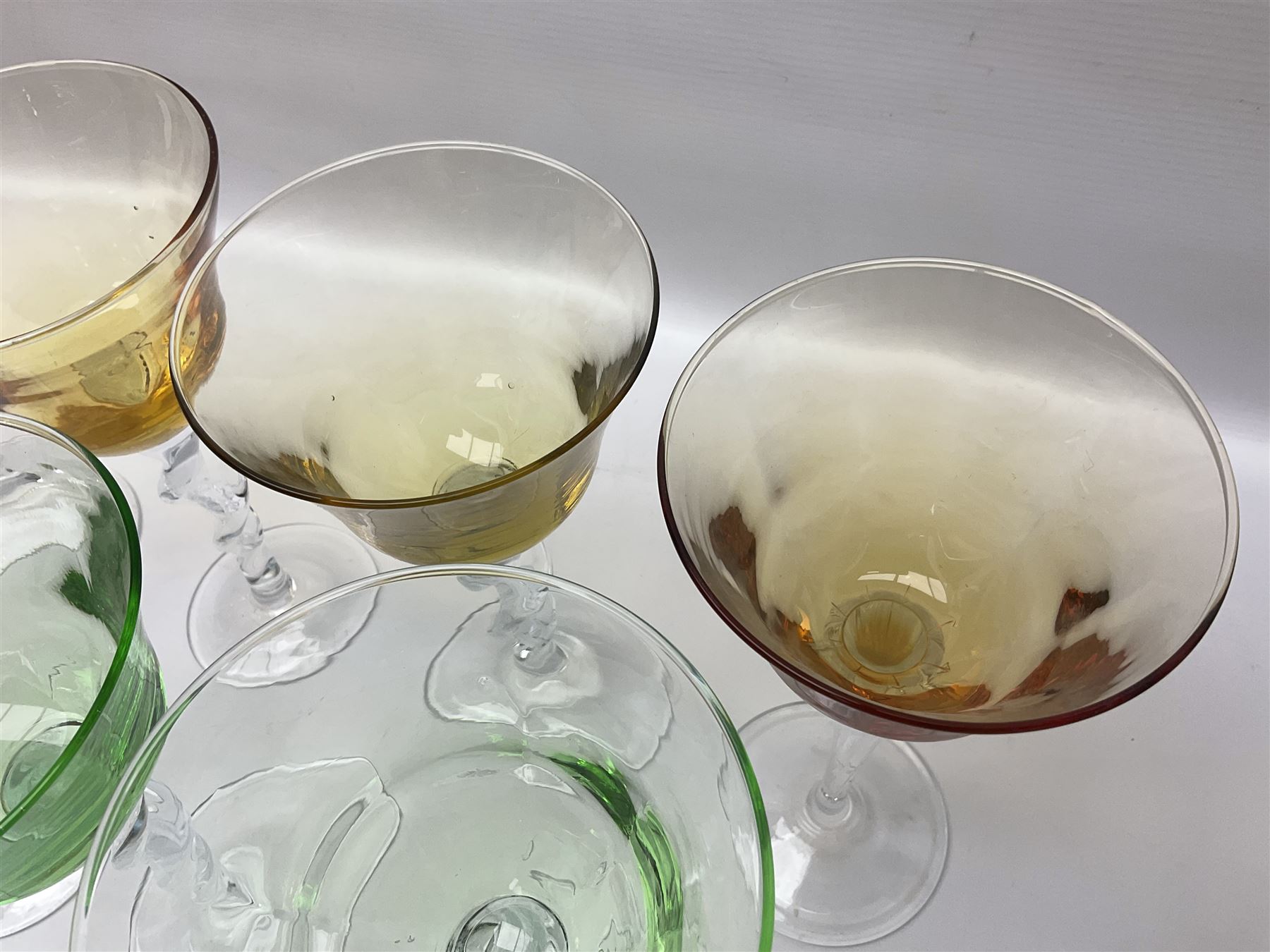 Ten coloured Adriana wine glasses by Abigails, to include blue, green, pink and yellow examples, each with part faceted bowl and twist stems, together with two similar orange examples with pulled stems, H24cm