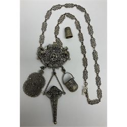 19th century continental silver plated chatelaine, the main body flanked with winged mythical beasts and central soldier slaying a dragon supporting three suspended items to include velvet lined small basket and long clasped filigree chain, together with a thimble