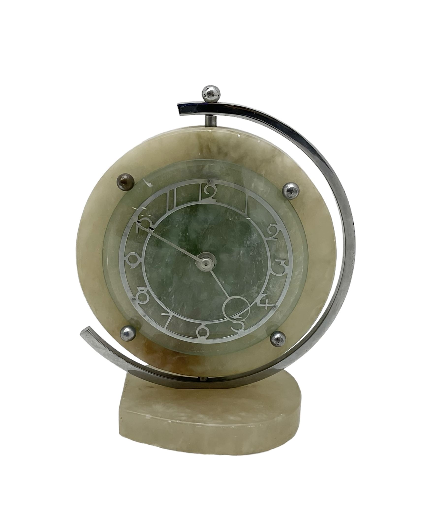 English 1920's Art Deco white-onyx mantel clock c1920, with a circular marble surround,  glass fronted chrome plated chapter with fretted Arabic numerals and conforming hands, movement and dial suspended in a semi-circular swivel gimbal mount, spring driven movement with a balance escapement, wound and set from the rear.