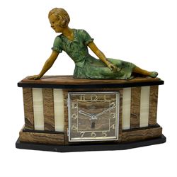 A 1950's Art Deco mantle clock in contrasting black, white and brown onyx marble, surmounted by a reclining spelter figure of a young lady, with a 6” square dial with a chrome bezel, Arabic numerals and chrome baton hands, with a timepiece spring driven movement.  With pendulum.

