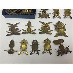 Over thirty British and Continental military metal badges; together with quantity of shoulder titles, collar dogs, rank pips, uniform buttons etc