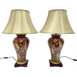 Pair of large table lamps of tapering form, decorated with Japanese blossom on a red groun...