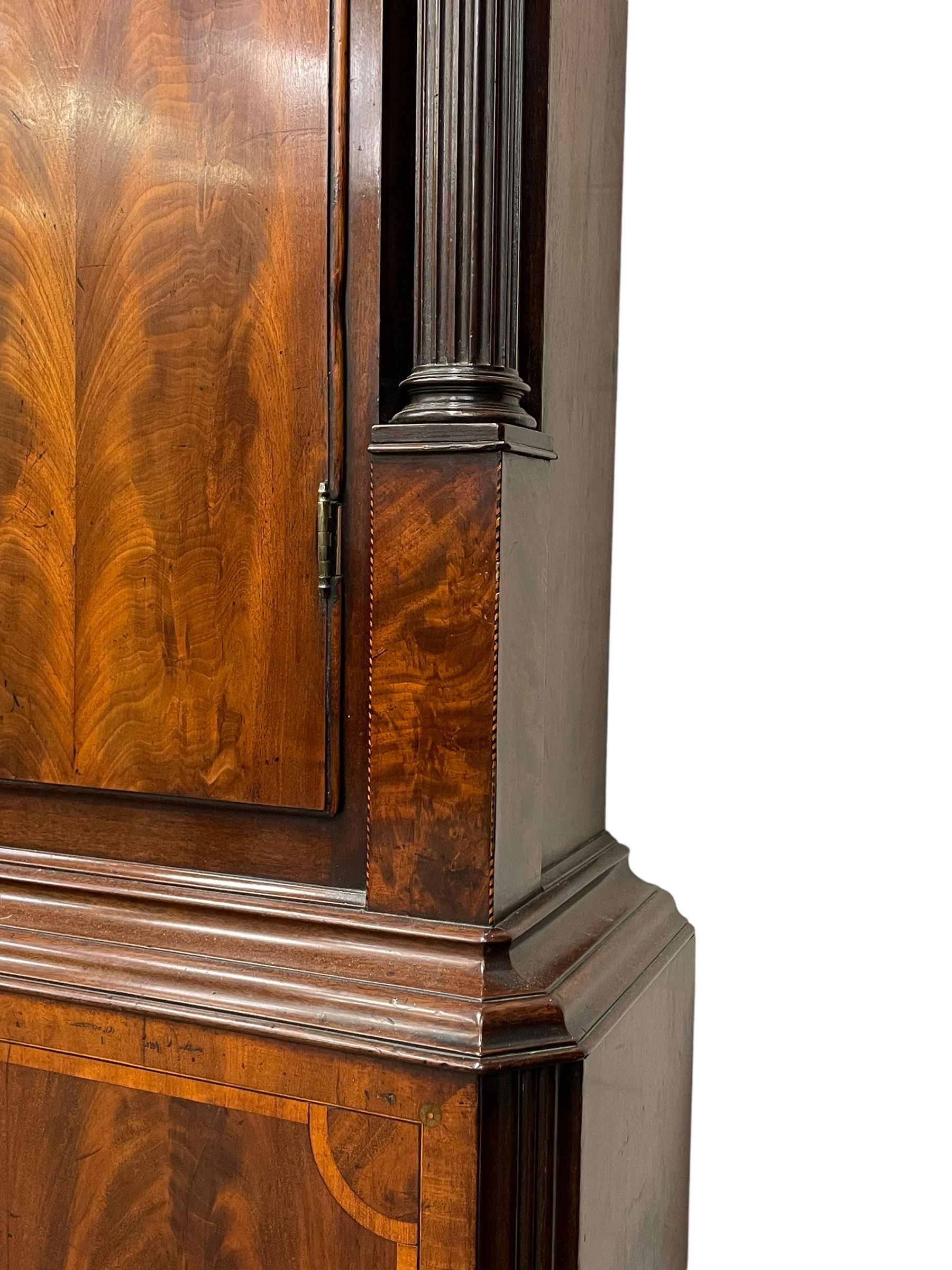 Penlington of Liverpool – early 19th century 8-day mahogany longcase clock, swans neck pediment with three turned wooden finials and verre eglomise panels, trunk with reeded columns and wavy topped door, plinth with canted corners on bracket feet, painted break-arch dial with Roman numerals and five-minute Arabic’s, centre sweep calendar and seconds hands, blue steel serpentine hands, signed beneath a painted rolling moon in the arch PENLINGTON, LIVERPOOL, eight day four pillar movement, anchor escapement and rack striking on a bell. With pendulum and weights.  The Penlington family were prolific clockmakers in 19th century Liverpool working from several addresses in the city, also recorded as chronometer and chronograph makers.