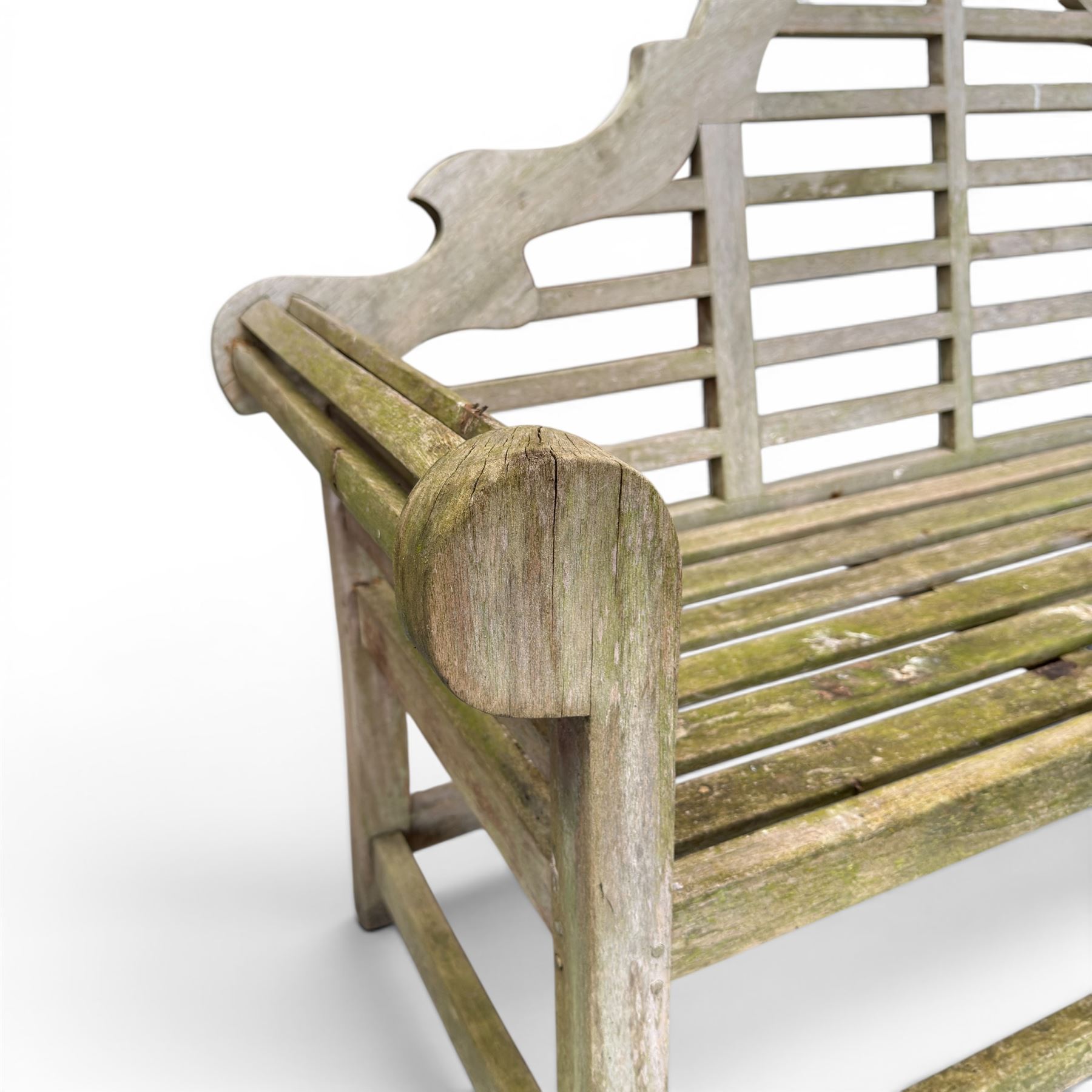 Lutyens design weathered teak garden bench with matching two-tier table, the bench with shaped arched and slatted back over rolled arms and slatted seat
