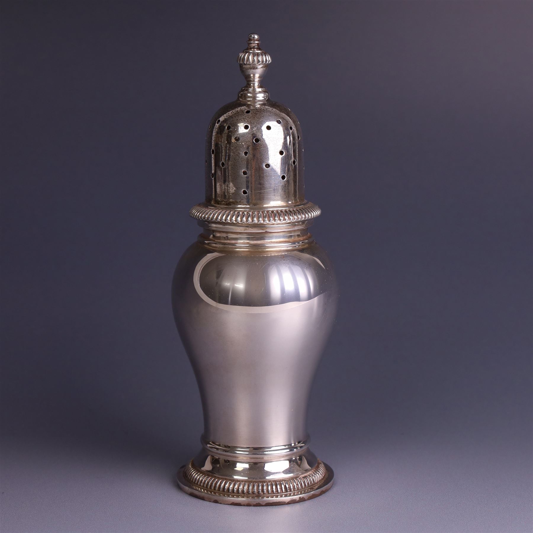Mid 20th century silver sugar shaker, of typical baluster form, the removable pierced cover with urn finial, hallmarked William Comyns & Sons Ltd, London 1961