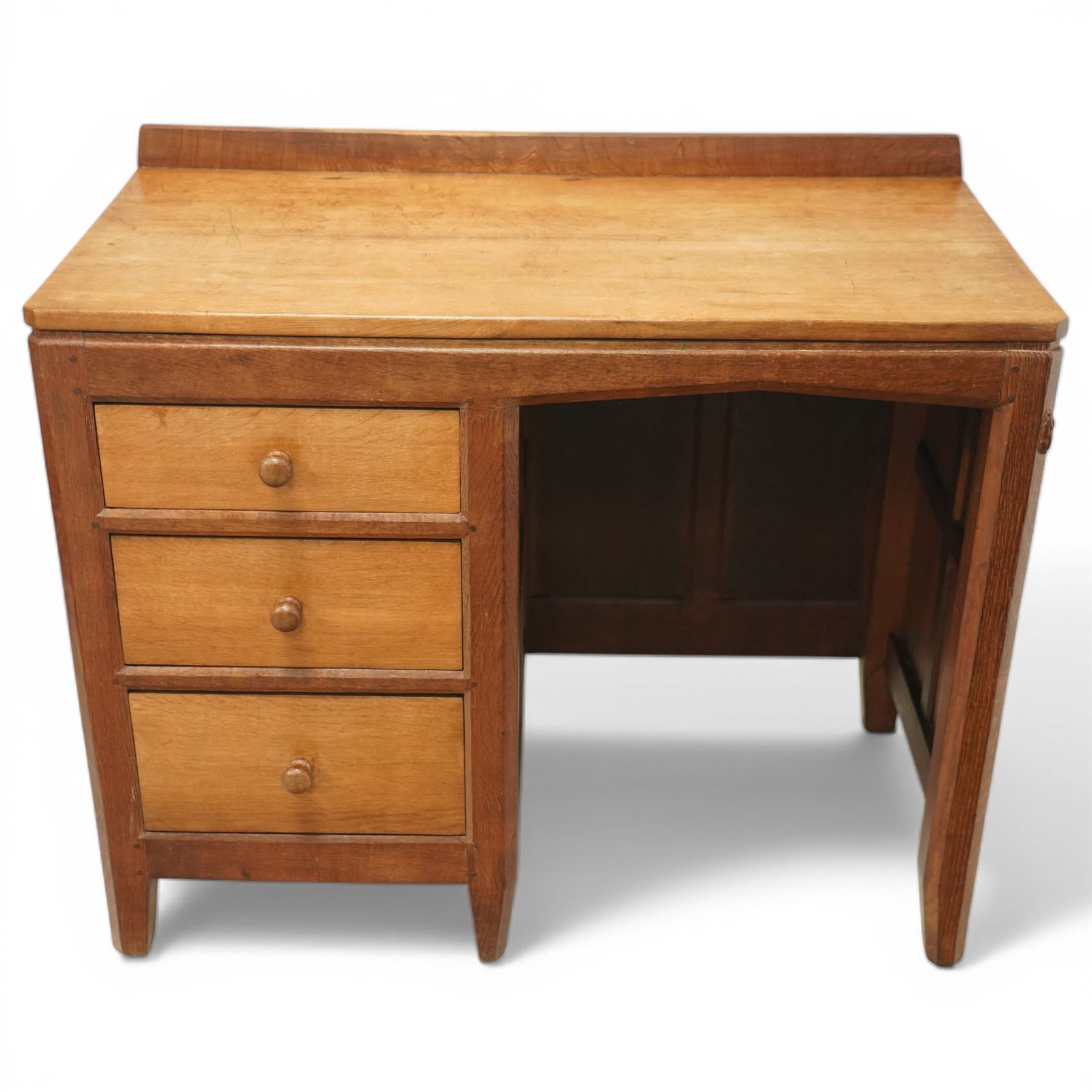 Rabbitman - oak single pedestal desk, adzed top with galleried back, with three graduating drawers with turned wooden knobs, enclosed kneehole with adzed detailing throughout the panelling and supports, with carved rabbit signature, by Peter Heap of Wetwang