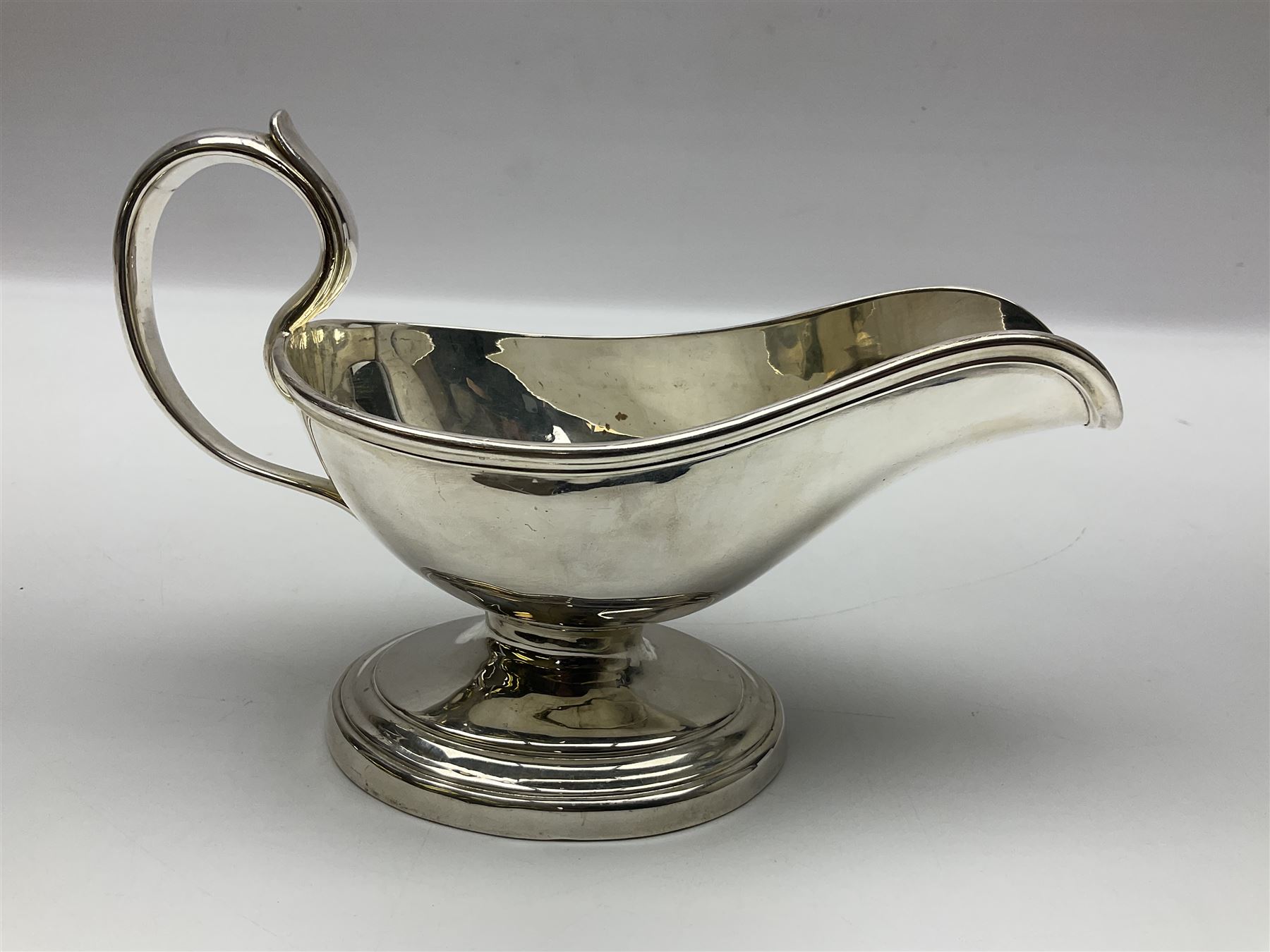 Christofle silver-plated sauce boat, of typical plain form, with capped C scroll handle and engraved anchor crest to body, upon a stepped oval foot, stamped 22 Christofle to base, including handle H14cm