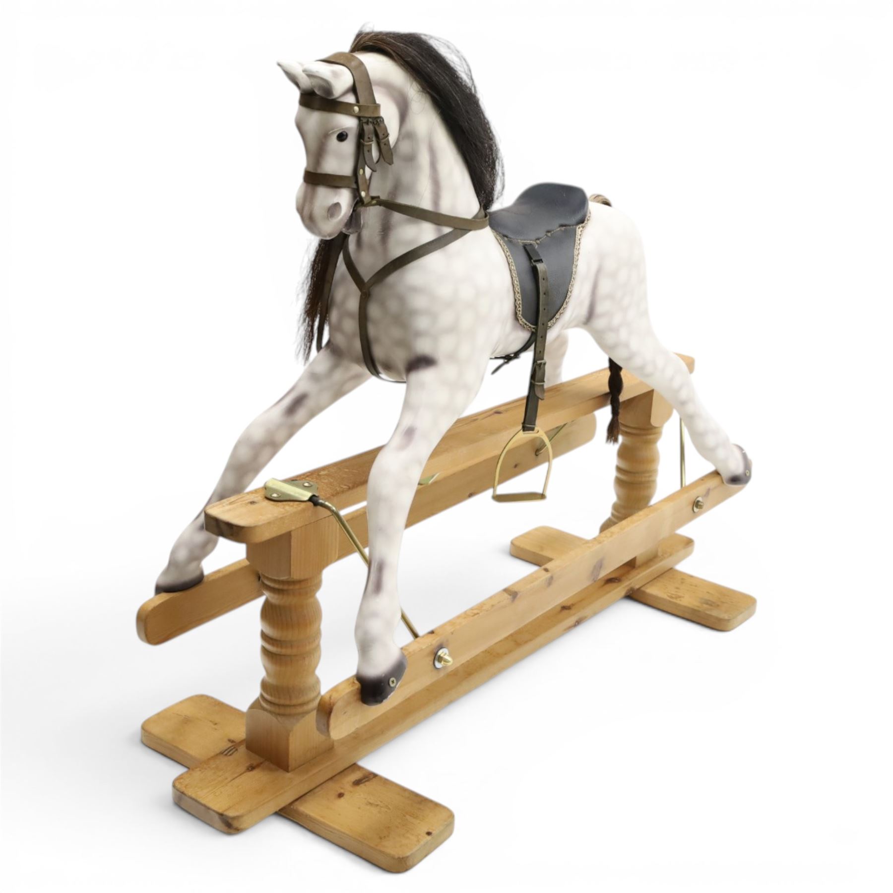 Late 20th century polychrome painted rocking horse, modelled in dapple grey finish with horse hair mane and tail, leather tack and saddle, stirrups, raised on a pine trestle base