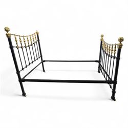 Victorian brass and iron 4' 6'' double bedstead, curved brass top rail with cast iron spindles and ornate floral rosettes flanked by urn shaped finials, foldable divan style base upholstered in a striped fabric, supported on turned posts and ceramic castors