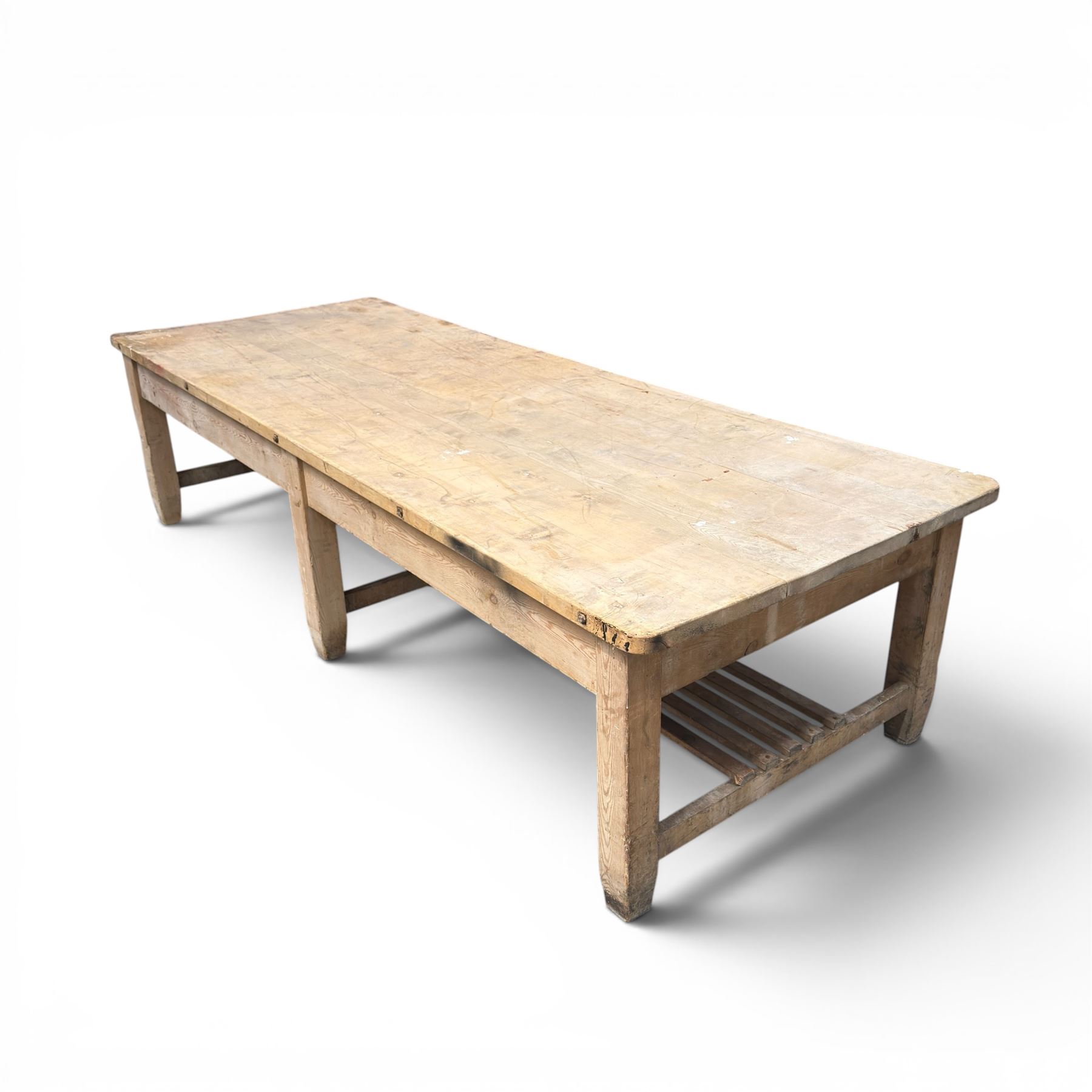 Large early/mid-20th century pine table or work bench, rectangular six plank top on eight tapering supports joined by slatted undertier