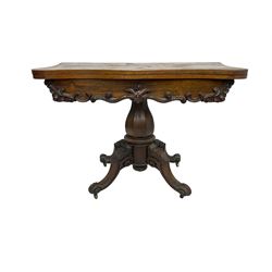 Victorian rosewood serpentine tea table, shaped fold-over and swivel top, the frieze decorated with carved scrolling foliate mounts, on octagonal faceted baluster pedestal, four scroll carved splay supports