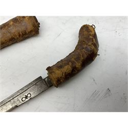 Near pair of African Moroccan Berber tribal Shula daggers each with engraved 39cm curving fullered steel blade, carved and inlaid horn grip and leather covered scabbard L57cm overall; kindjal style dagger with brass covered and jewelled grip and scabbard; another Eastern dagger with leather covered grip and scabbard; and a large Eastern knife with animal hide scabbard (5)