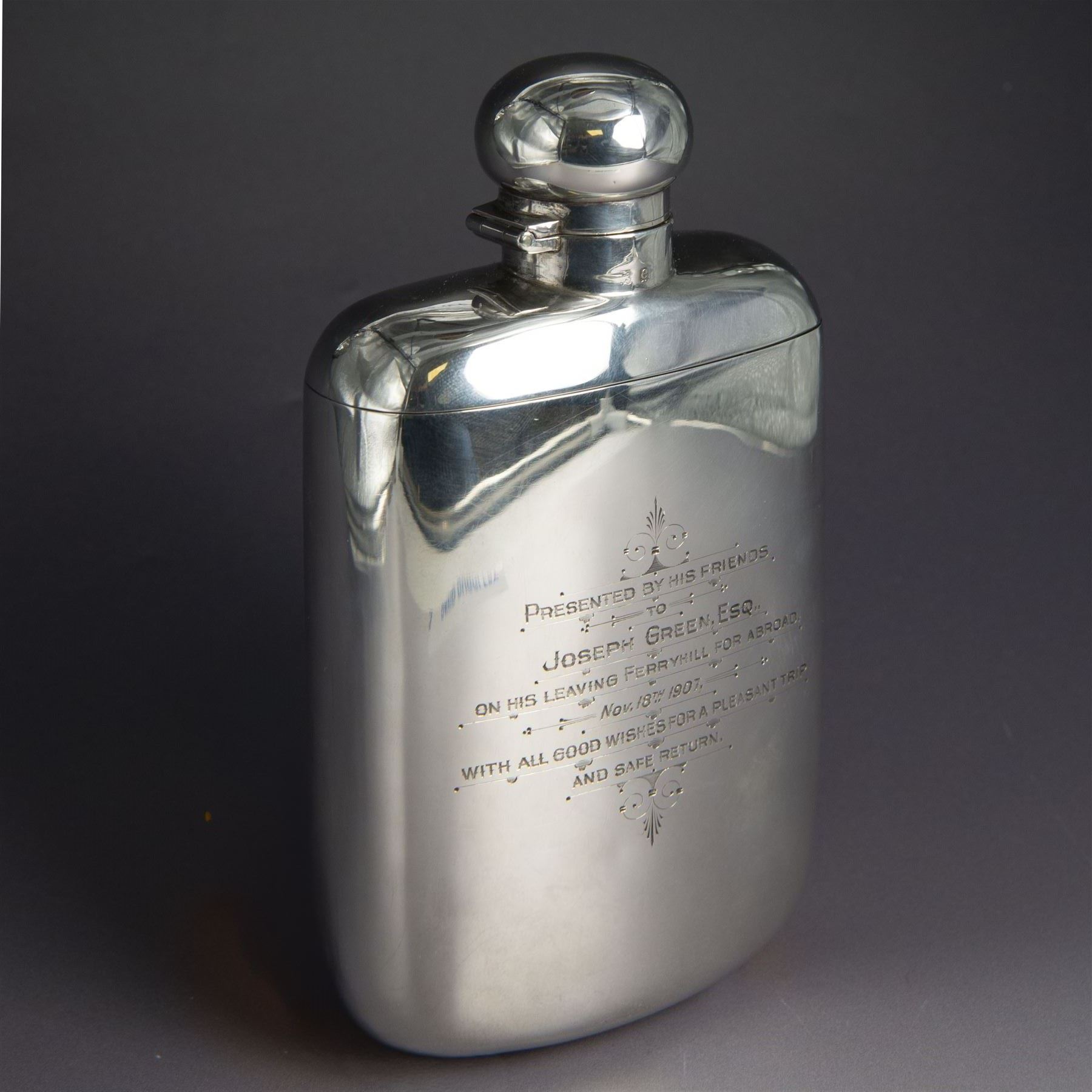 Edwardian silver hip flask, of slightly curved rectangular form, with silver body, hinged cap and removable silver cup, the cup with presentation engraving and gilt interior, hallmarked Hilliard & Thomason, Birmingham 1904, H17cm