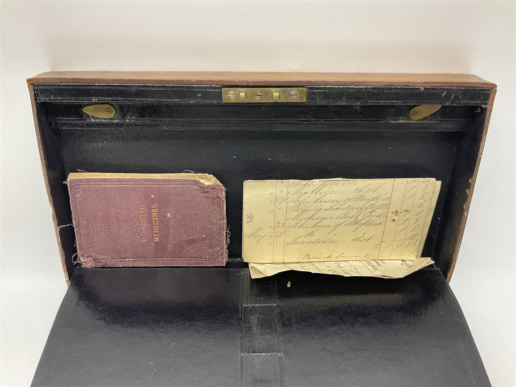 19th century apothecary leather carrying case, with key, the hinged lid opening to reveal seventeen glass medicine bottles with stoppers, most with chemist labels, gram scales, and domestic medicines booklet, H9cm, L27cm