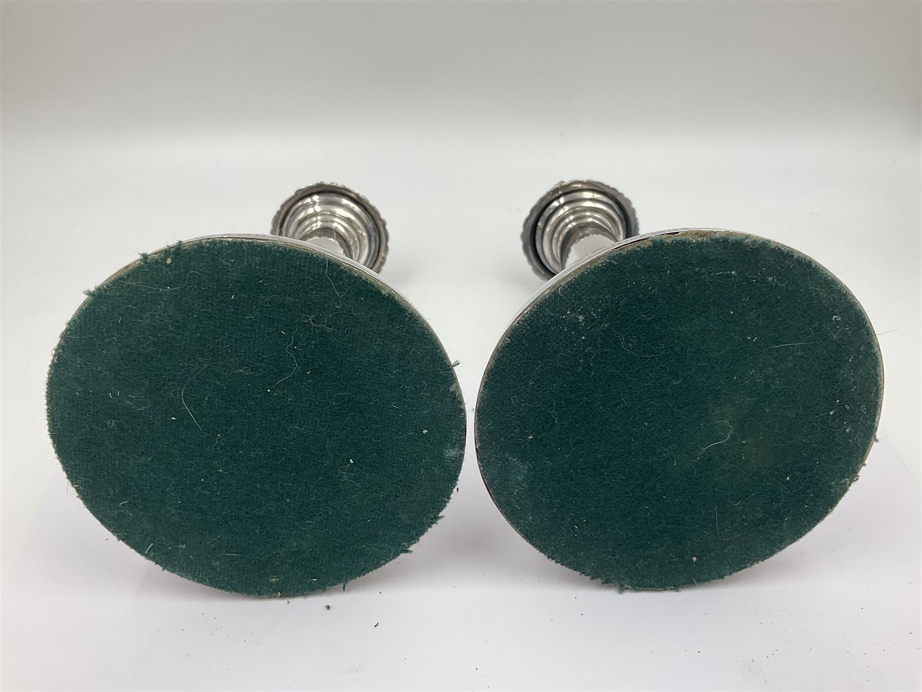 Four George III silver candlesticks, each upon knopped stem and weighted circular stepped foot, the foot and removable sconce repousse decorated with a band of flower heads, hallmarked to sconce and foot Thomas & John Settle, Sheffield 1820, H17.5cm