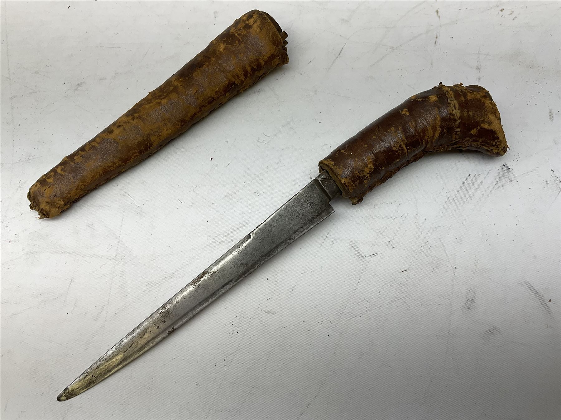 Near pair of African Moroccan Berber tribal Shula daggers each with engraved 39cm curving fullered steel blade, carved and inlaid horn grip and leather covered scabbard L57cm overall; kindjal style dagger with brass covered and jewelled grip and scabbard; another Eastern dagger with leather covered grip and scabbard; and a large Eastern knife with animal hide scabbard (5)