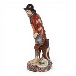 Mid 18th century Furstenberg figure, modelled as a beggar or mendicant with peg leg and ba...