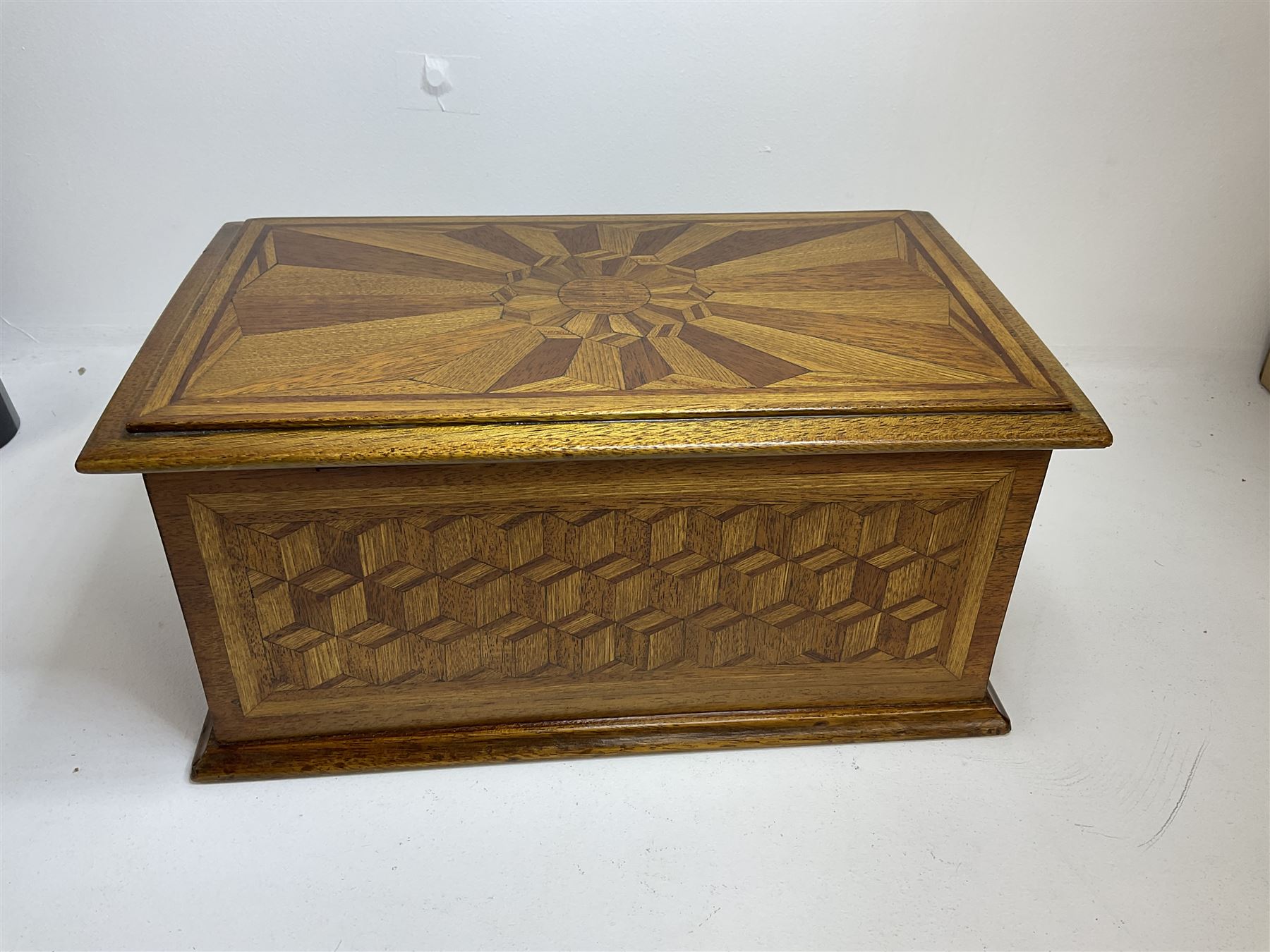 19th Century mahogany and parquetry box of rectangular form, geometric cube design, with a stylised sun detail to the hinged cover, opening to reveal three compartments, L33cm D21cm H16cm
