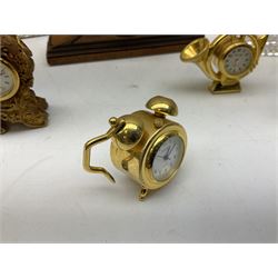 Collection of miniature clocks, predominantly with quartz movements, to include example modelled as an armchair, Edinburgh crystal glass example, clock modelled as a flower, sewing machine etc