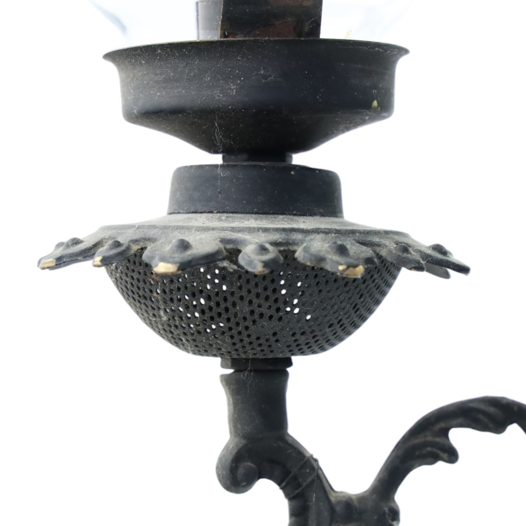 Late 19th century wrought metal hanging ceiling lamp, the ornate pierced central reservoir-form body with mounted eagle, three scrolling branches fitted with three clear glass chimney shades, suspended by decorative chains from a pierced ceiling rose