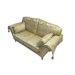 Steed Upholstery - two seat traditional shaped sofa, upholstered in cream fabric with scrolling foliate pattern, on turned front feet with brass castors, with side cushions and arm covers