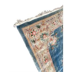 Large Chinese blue ground woollen carpet, overall floral design, central oval medallion surrounded by scrolling floral decoration, wide border with decorated with floral bouquets 