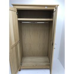 Light oak double wardrobe, projecting cornice, two doors enclosing fitted interior, stile supports 