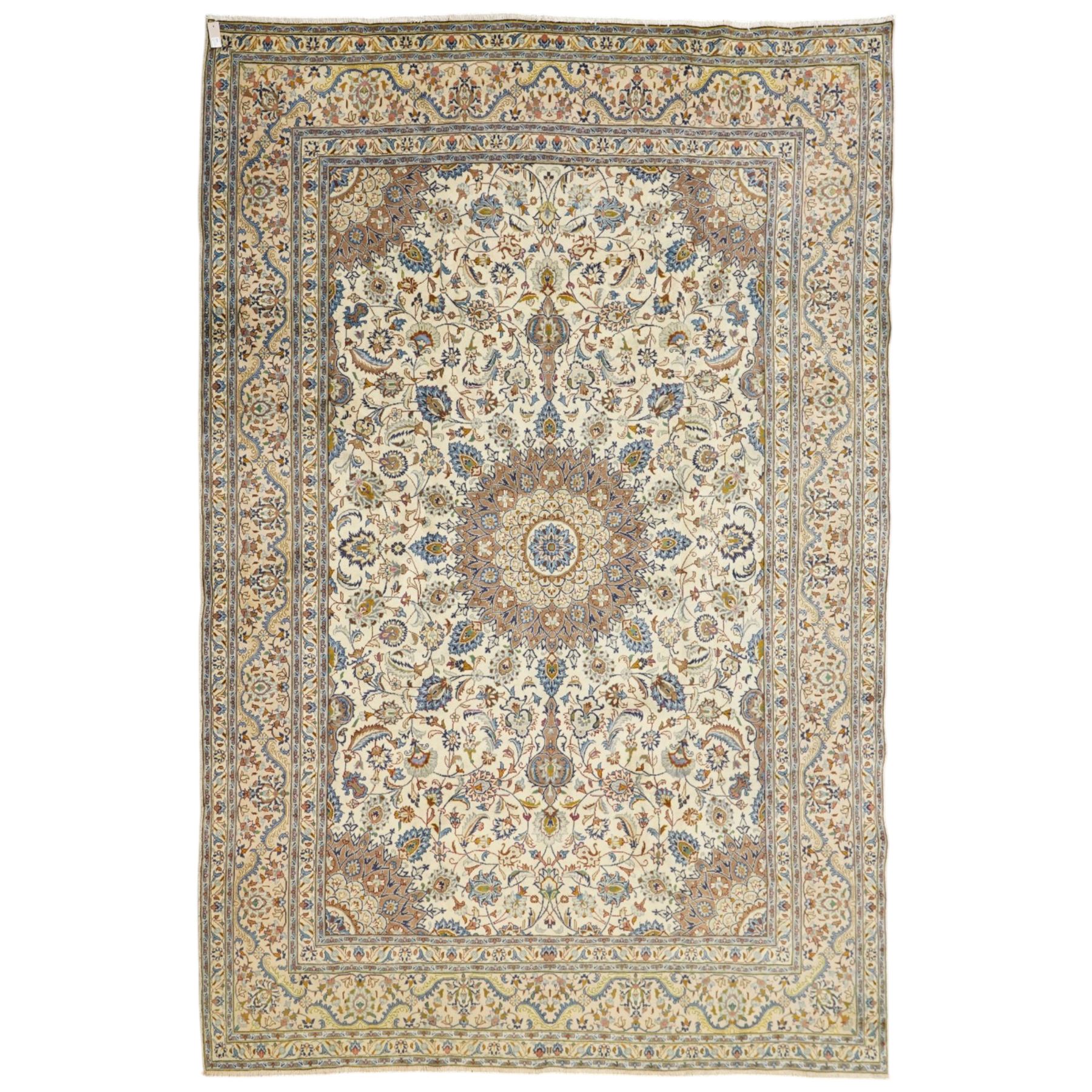 Central Persian Nain hand-knotted carpet, ivory field with central radiating medallion with pendants, issuing an all-over design of scrolling vines, palmettes, and floral sprays within confirming spandrels, framed a complimentary foliate border flanked by multiple guard stripes, with cotton fringe ends 