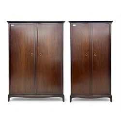 Stag Minstrel - pair of mahogany double wardrobes, comprising a larger wardrobe with a shelf and hanging rail behind two panelled doors (W127cm, D59cm, H177cm); and a smaller wardrobe enclosing a single hanging rail (W96cm, D59cm, H177cm), both finished with projecting cornices and raised on bracket feet



