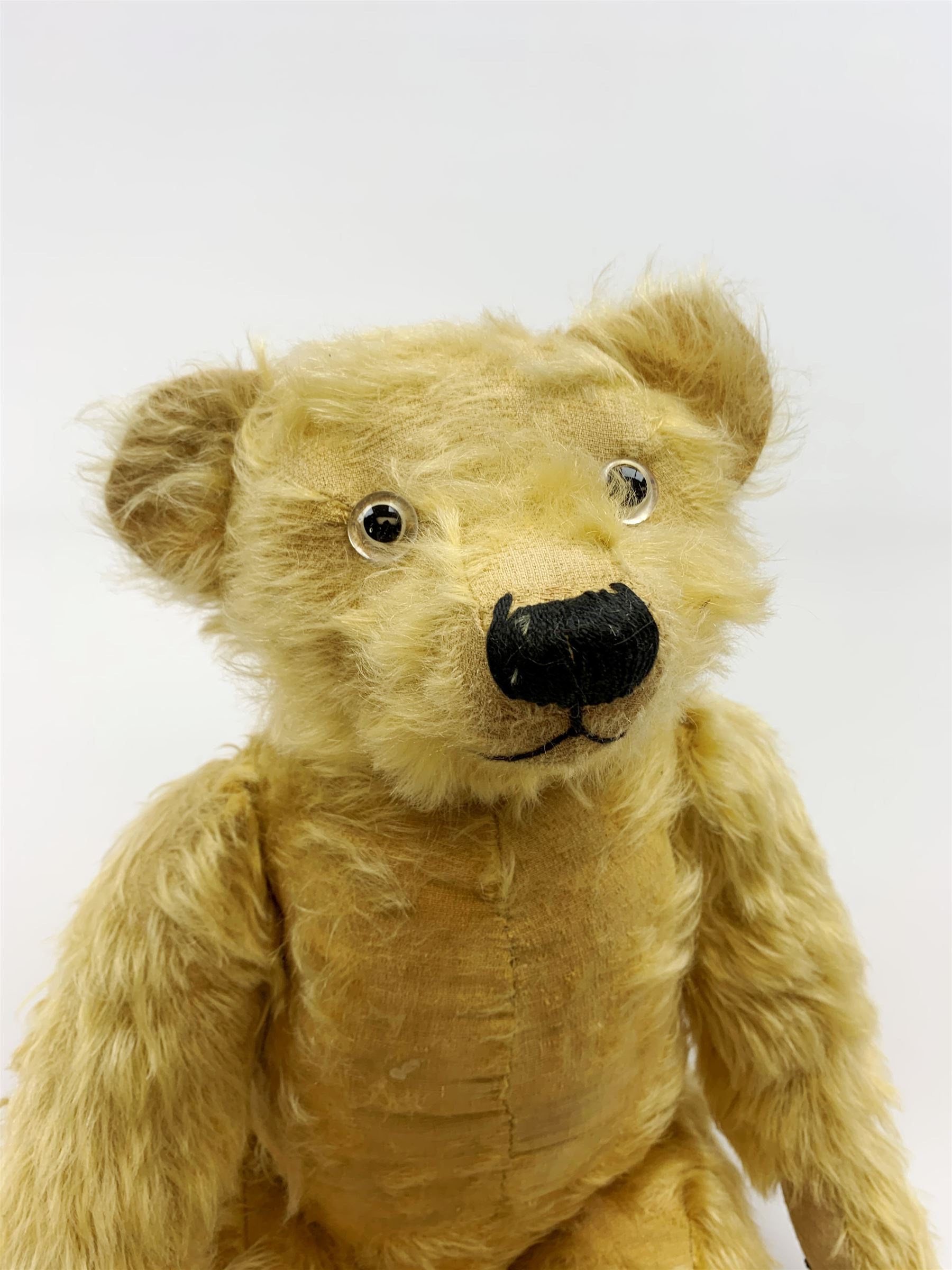 Alpha Farnell Toys large blonde mohair teddy bear with glass eyes, vertically stitched nose and mouth and jointed limbs with stitched claws, label to right foot pad H23.5