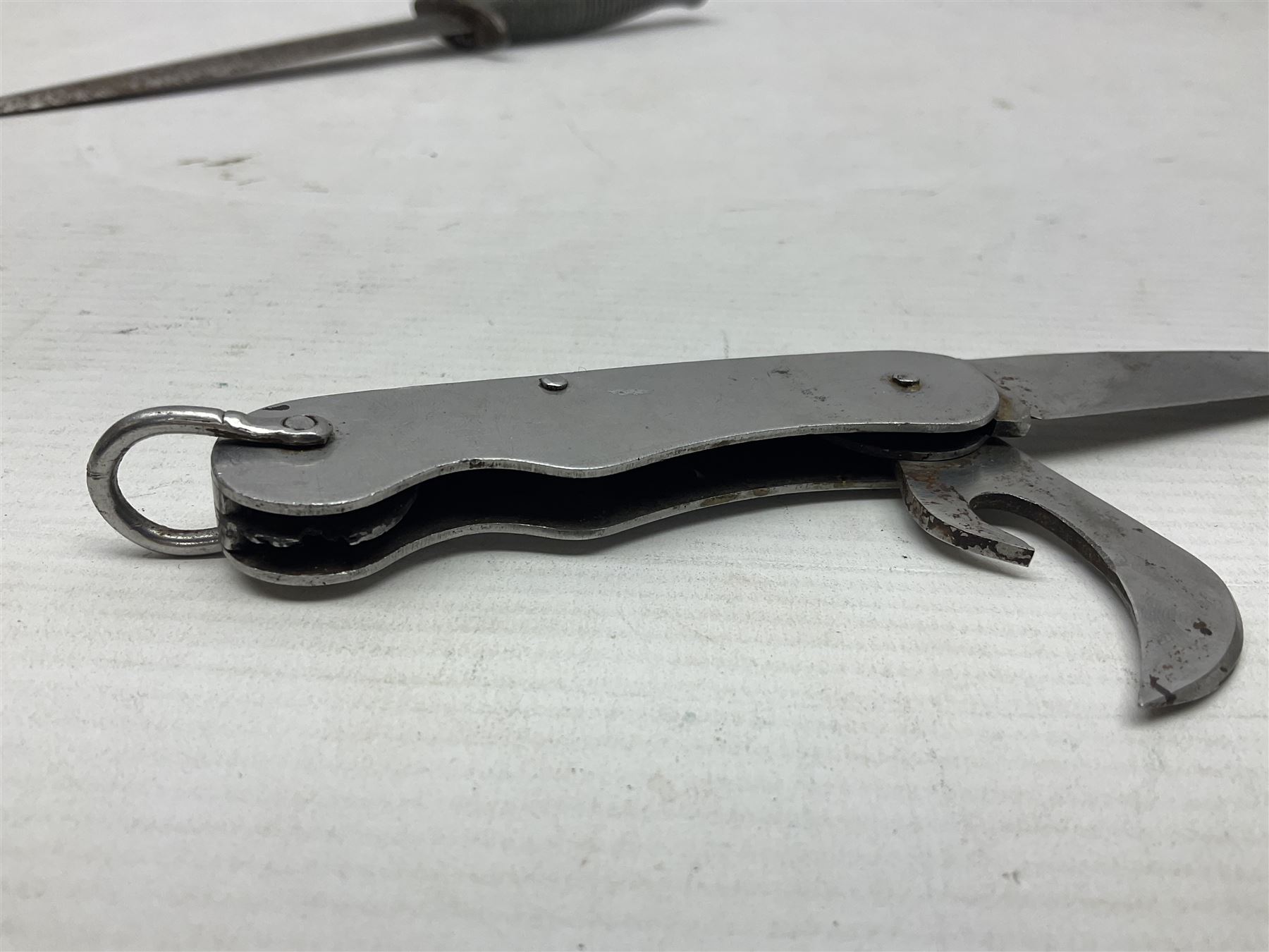 Fairburn Sykes style third pattern commando fighting knife, the 16cm double edged blade with central medial ridge, steel cross-piece marked with broad arrow and 'I', ribbed alloy grip L28cm overall (no scabbard); and Warriss Sheffield military pocket knife with two folding blades, marked with 'broad arrow 1953 and Oil The Joints' (2)