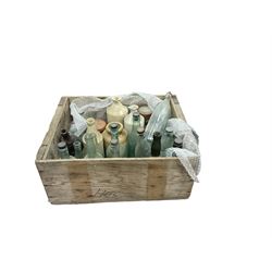 Quantity of mostly vintage glass bottles including examples of local interest, other glass jars and stoneware etc in wood crate