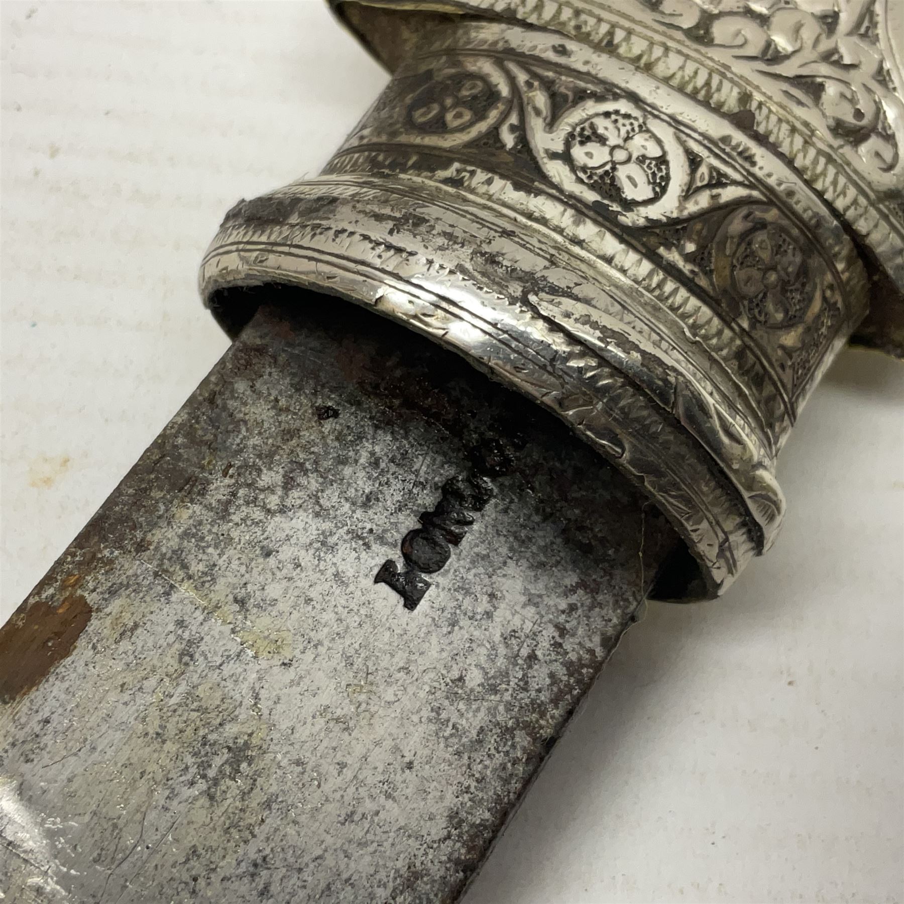 Moroccan jambiya dagger with 24.5cm plain curved blade stamped LONDON to the ricasso area, the hilt and scabbard overlaid with plain sheet brass to the back and ornate silver coloured metal to the front; waisted grip and arched pommel; two pyramid mounts to the scabbard L41cm overall; large billhook with curving blade and stacked leather washer grip; and a reproduction halberd blade (3)