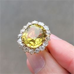 Early 20th century gold chrysoberyl and diamond cluster ring, single cushion cut yellow / green chrysoberyl of approx 8.00 carat, surrounded by sixteen old cut diamonds, stamped 18ct, total diamond weight approx 1.10 carat