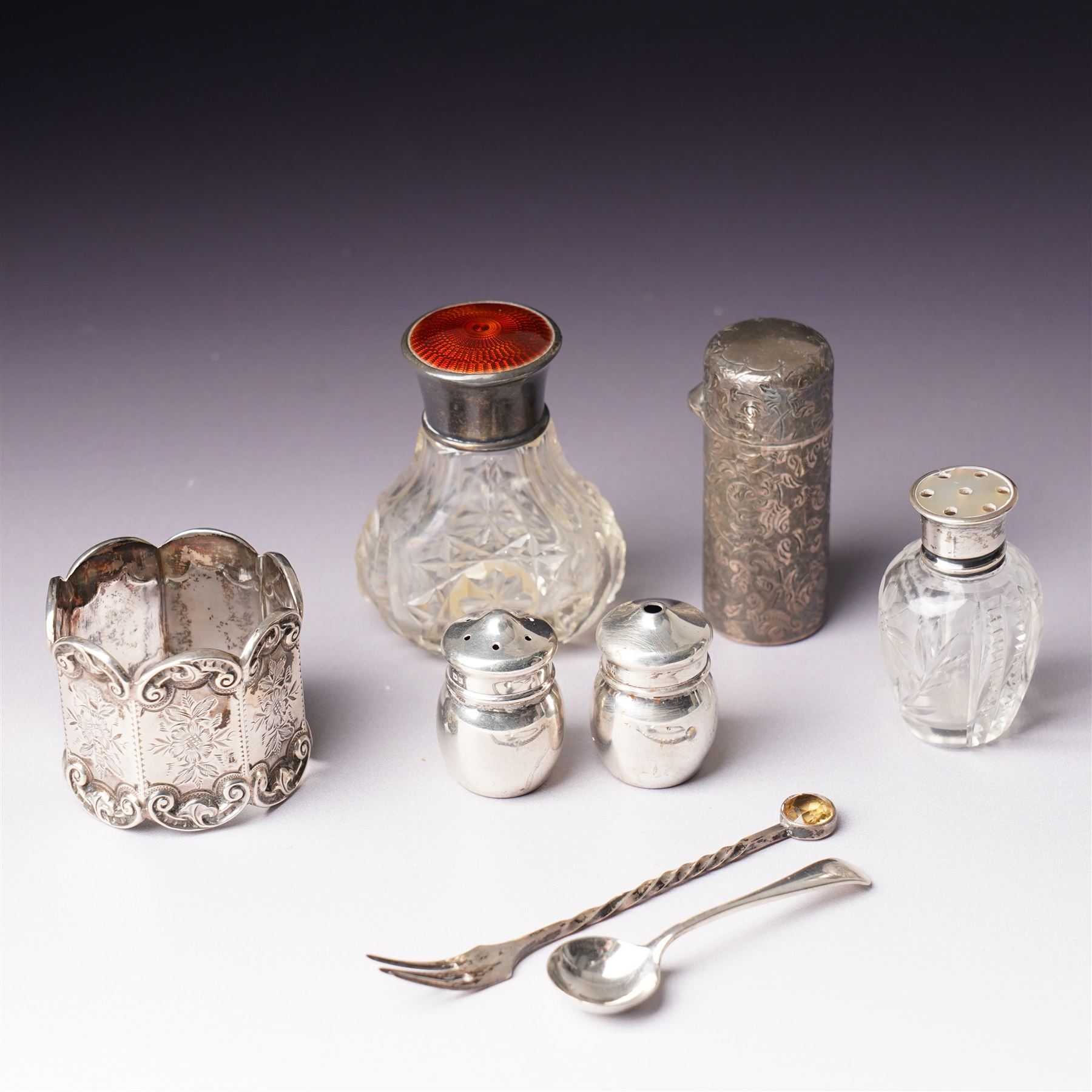 Small glass scent bottle with silver and red enamel cover, Edwardian silver cased scent flask with engraved decoration, heptagonal silver napkin ring, pair of small silver barrel shape salts, glass pepperette with silver and mother of pearl cover, small silver stone set fork by William Robb and a silver salt spoon