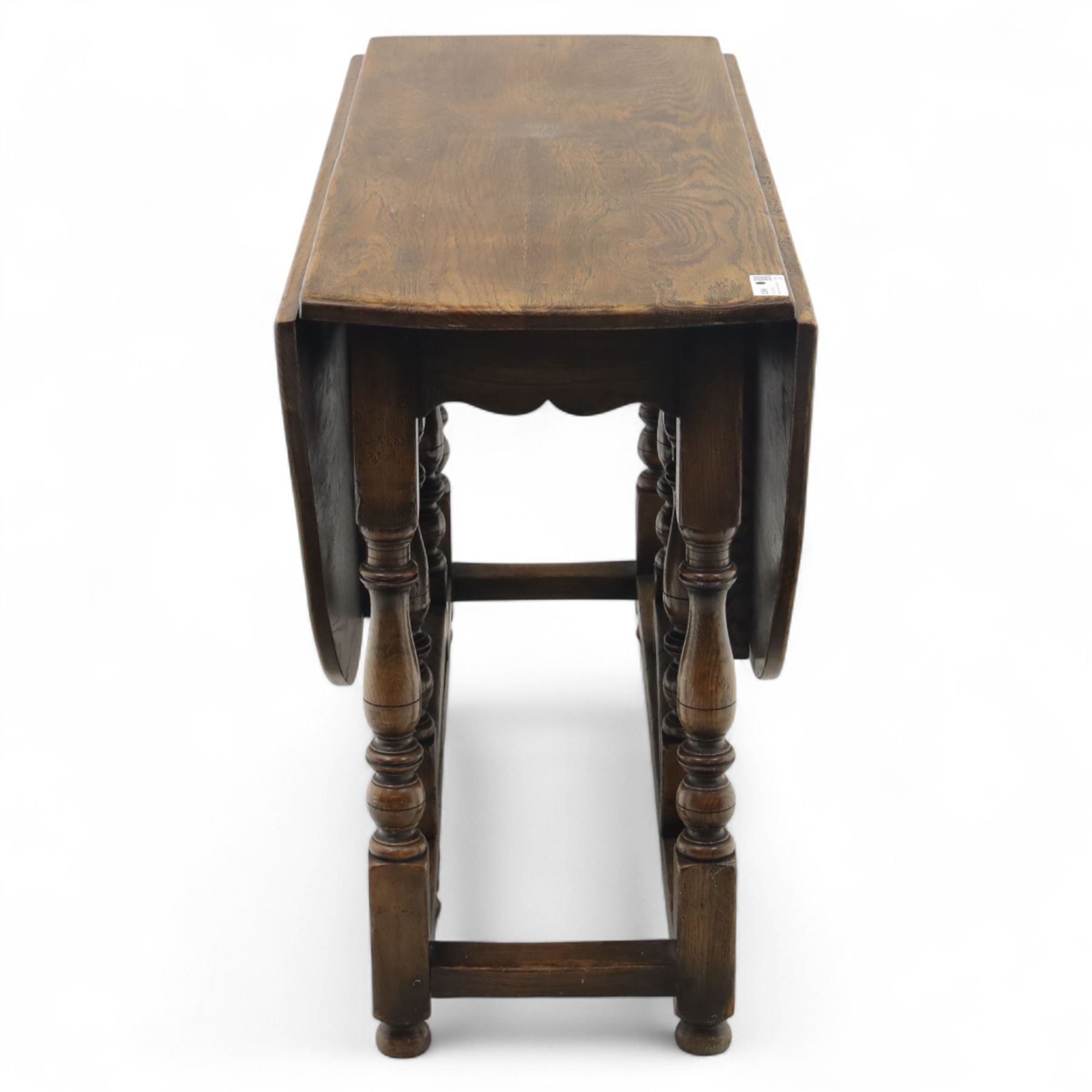 17th century design oak gateleg dining table, oval drop-leaf top on baluster turned supports, twin swinging gate legs united by peripheral stretchers (Extends to 149cm)